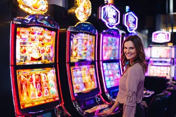 A woman smiling by bright slot machines showing lucky symbols, showcasing the exciting slot offerings at 456DB.