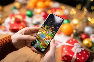 A player using their smartphone during a festive local event, representing 456DB’s fully mobile-friendly casino.